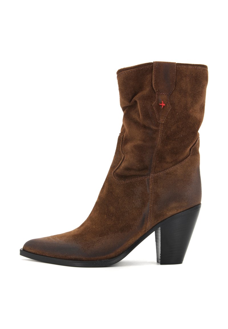 Stivale ankle in suede marrone con un design arricciato, punta affusolata, tacco a blocco nero e un piccolo dettaglio rosso sul lato.