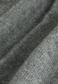 Woven fabric in varying shades of gray, featuring a textured herringbone pattern with a soft, warm finish.
