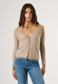 Beige striped cardigan with a v-neck, long sleeves, and button-up front. Features blue stripes and a textured knit material. Worn with blue jeans.