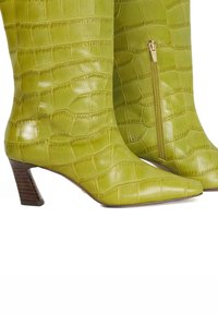 Green leather heeled boots with a crocodile texture, pointed toes, and a side zipper. Wooden block heels add structural detail.