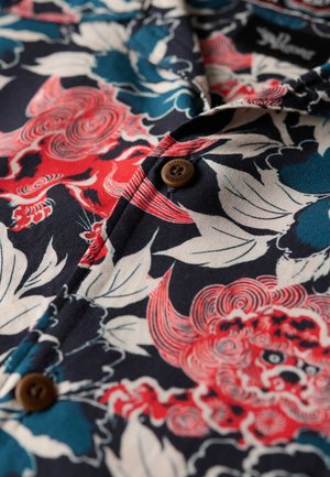 Korte mouwen shirt met een marineblauwe basis, voorzien van rode en blauwe bloemenpatronen, een bruine knop en een gestructureerde stof.