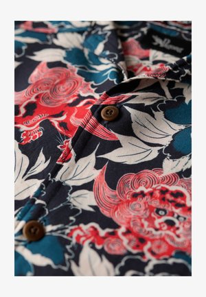 Korte mouwen shirt met een marineblauwe basis, voorzien van rode en blauwe bloemenpatronen, een bruine knop en een gestructureerde stof.