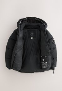 Giacca imbottita nera con cappuccio aperto, che mostra etichette e loghi interni inclusi "Baker by Ted Baker" sul colletto, sul petto e sulla manica.