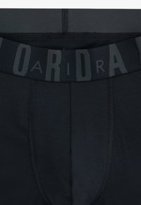 Boxers noirs avec taille élastique large portant l'inscription 'ARIDA' en gris, texture lisse et coutures plates pour le confort.