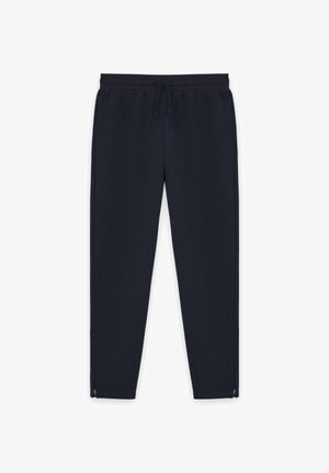 Marineblaue sweatpants mit engem Schnitt, elastischem Bund, Kordelzug, Seitentaschen und Reißverschlüssen an den Knöcheln.