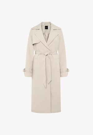 Trench-coat beige clair avec larges revers, taille cintrée par une ceinture, et bracelets aux poignets, doté d'un rabat d'épaule sur le côté droit.