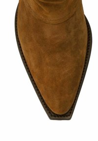 Bottine en suède marron avec un bout pointu, une surface texturée et un contour en cuir foncé autour de la base. Aucune motif visible ni quincaillerie.