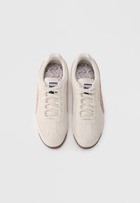 Αθλητικά παπούτσια από σουέντ σε ανοιχτό μπεζ με ροζ λεπτομέρειες, στρογγυλή μύτη, επίπεδη δέσιμο με κορδόνια και σχέδιο στην εσωτερική σόλα. Διαθέτουν λογότυπο στη γλώσσα.