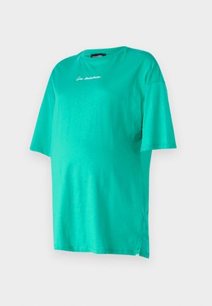 Tirkīza krāsas pārāk liels T-krekls no mīksta kokvilnas, ar īsām piedurknēm, apaļu kakla izgriezumu, izšūtu "la mama" detaļu un sānu izgriezumiem ērtībai.