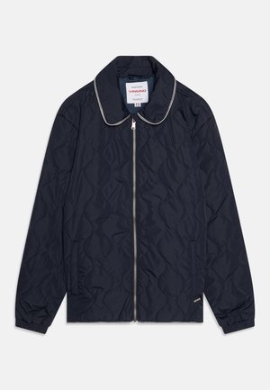 Marineblå quiltet jakke med ståkrage, sølvglidelås, elastiske mansjetter og sidelommer. Har et subtilt bølgemønster på stoffet.