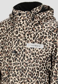 Vandafvisende jakke i leopardmønster med en beige baggrund, der har en blød sort foring, trykknapper og et logo-patch på brystet.