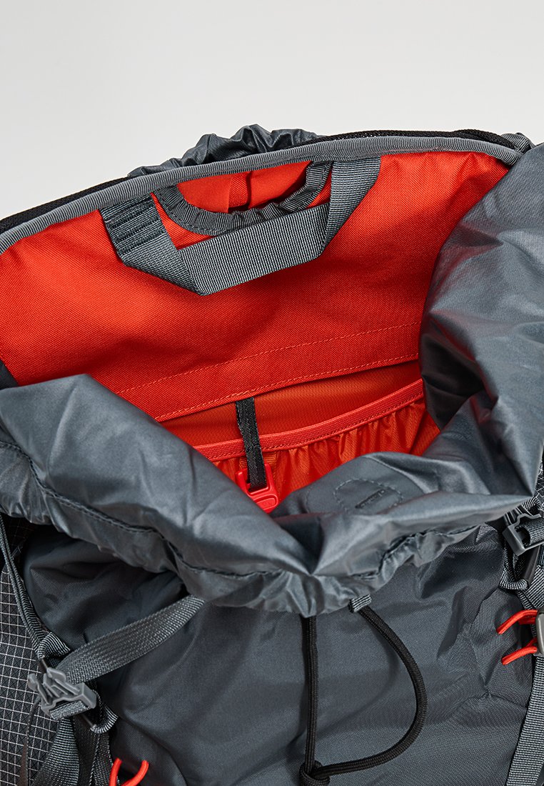 Rugzak met een grijze nylon buitenkant en rode stoffering. Voorzien van een trekkoordsluiting aan de bovenkant en een binnenzak met elastische rand. Minimalistisch ontwerp.