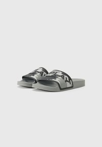Gray rubber slide sandals with a wide strap featuring black text and a camouflage pattern. Flat sole and rounded toe design.