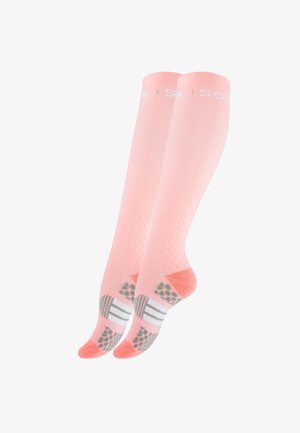 Chaussettes de compression roses avec des semelles texturées antidérapantes. Elles se caractérisent par une couleur unie avec un logo blanc en haut et des accents à motifs en bas.