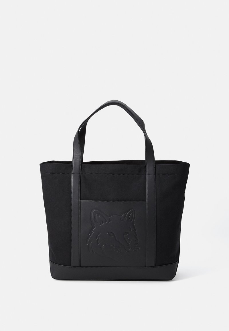 Bolsa de mano negra con una tela texturizada y detalles de cuero, que presenta un diseño de zorro en relieve en la parte frontal, asas resistentes y forma rectangular.
