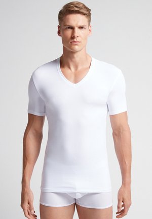 T-shirt blanc à manches courtes en V, fabriqué en tissu extensible, design ajusté, texture lisse, associé à un boxer blanc.