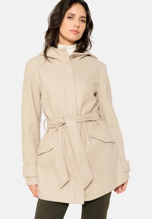 Beige gewatteerde jas met een strikceintuur, voorzien van twee voorzakken en een textuurstof. Het ontwerp omvat een knoopsluiting en manchetten.