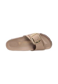 Sandalo in gomma beige con una larga fascetta, fibbia regolabile in tono oro e soletta testurizzata per il comfort. Suola piatta con leggere scanalature.