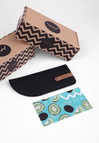 Black felt pencil case with a rounded edge and brown leather accent, alongside a patterned card featuring kiwi illustrations on a blue background.