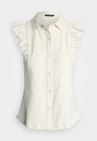 Blouse sans manches en crème, présentant des épaules volantes, un devant à boutons, un col pointu et une coupe décontractée. Tissu lisse et léger.