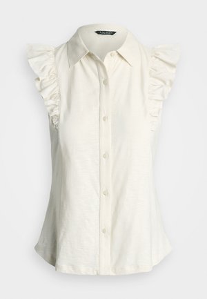 Bílá halenka bez rukávů s límečkem, zdobená volánky na ramenou a s knoflíkovou légou vpředu. Vyrobena z lehké látky.