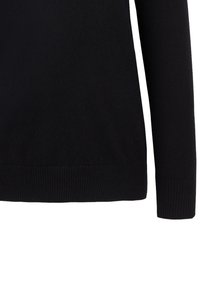 Schwarzer Langarmpullover mit gerippten Bündchen und Saum, von der Taille bis zum Handgelenk auf weißem Hintergrund gezeigt.