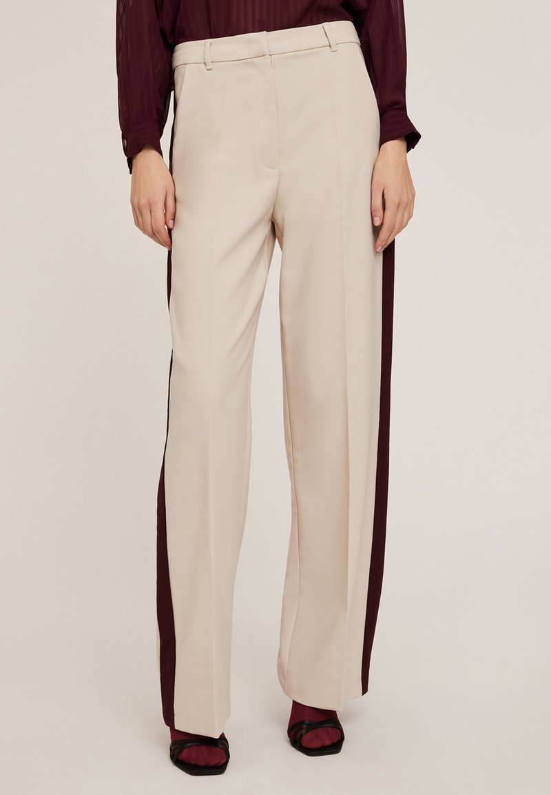 Beige wijde broek met kastanjebruine zijkanten. Gemaakt van gladde stof met een aansluitende tailleband en zonder zichtbare zakken.