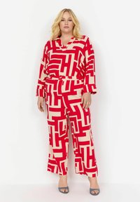 Karminrot- und cremefarbenes gemustertes Zweiteiler-Outfit mit einem Langarmtop und weit geschnittenen Hosen, hergestellt aus weichem Stoff mit einem elastischen Bund.