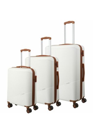 Three white hardshell suitcases with vertical ribbed texture, brown accents, retractable handles, and four spinner wheels.