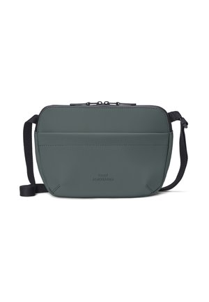 Compact dark green crossbody bag with front pocket, black adjustable strap, and two zipper pulls on top.