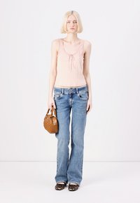 Light pink ribbed tank top with a bow detail, blue flared jeans, brown woven handbag, and leopard print flat shoes. Simple design elements.