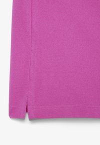 Lila texturerad tyg med ett subtilt mönster; har sidoflikar vid fållen för extra detaljer och design. Materialet verkar vädertåligt.