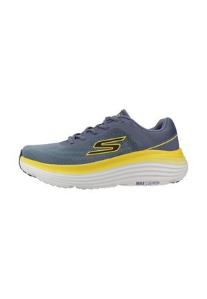 Zapatilla de correr para hombre de Skechers en gris y amarillo con suela blanca gruesa y marca "Max Cushion" en el lateral de la suela.