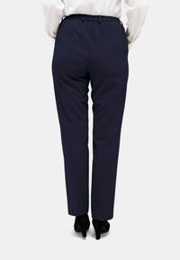 Marineblauwe geruite broeken met een tapered fit en elastische tailleband, met een soepele textuur en zijzakken, gecombineerd met zwarte hakken.