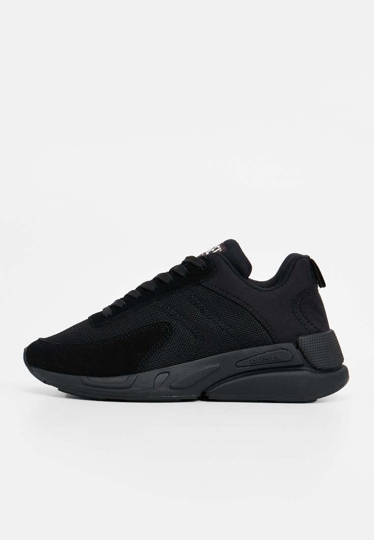 Des chaussures de sport noires présentent un mélange de matériaux en maille et en daim, une semelle texturée et une languette au talon pour un enfilage facile.