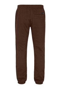 Bruine joggingbroek gemaakt van zachte stof met een elastische tailleband, elastische boorden en een enkele achterzak.