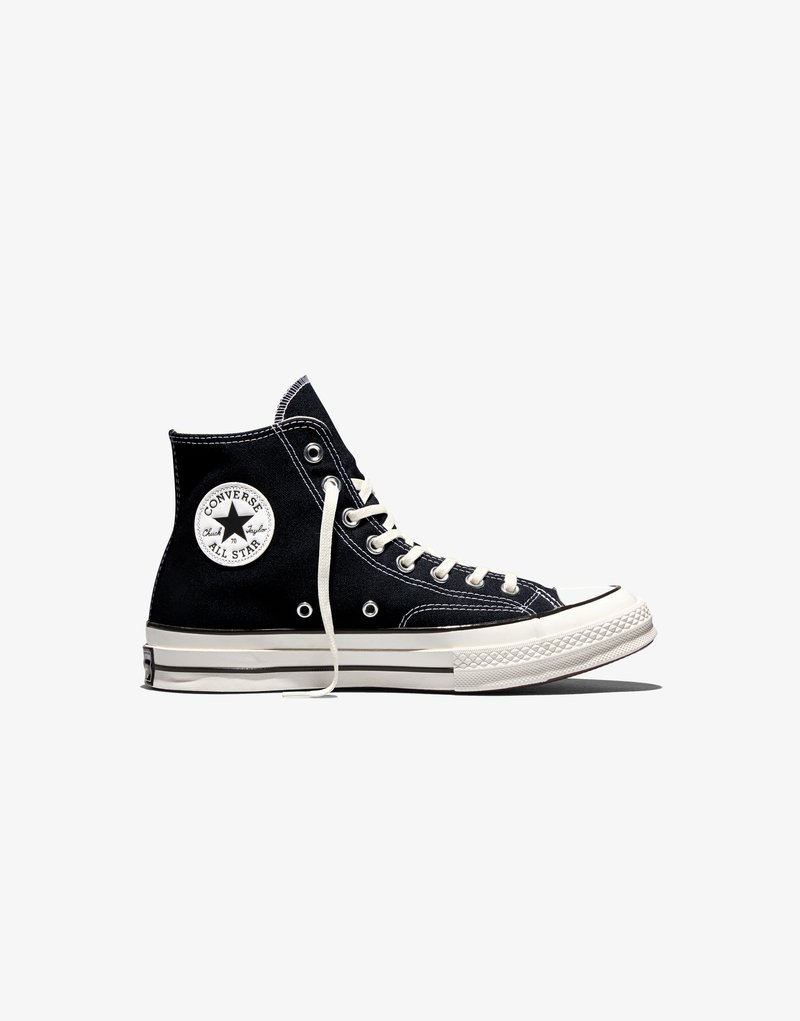 Scarpa alta nera Converse Chuck Taylor All Star con lacci bianchi e suola in gomma su sfondo bianco.