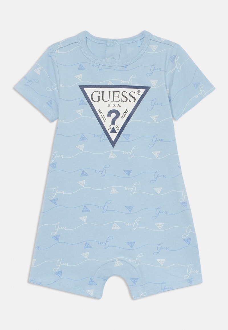 Šviesiai mėlynas trumpas rankovėmis romperis su baltais bangų ir trikampio raštais, viduryje esantis juodas trikampio logotipas su prekės ženklu „GUESS“.