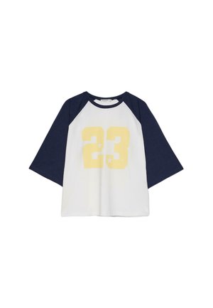 Maglietta bianca e blu navy con maniche raglan, numero giallo 23 e piccoli dettagli a stella al centro davanti.