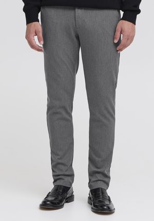 Grijze op maat gemaakte broek van textuurstof, slanke pasvorm, met een platte voorkant, zijzakken en gedragen met zwarte leren instappers.