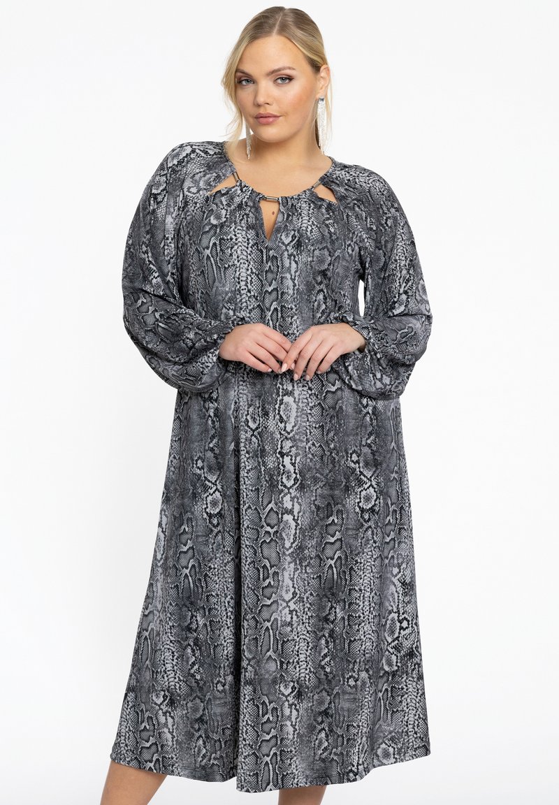Robe longue à imprimé serpent noir et blanc avec des manches longues, un décolleté en trou de serrure et une coupe fluide et décontractée. Texture de tissu lisse.
