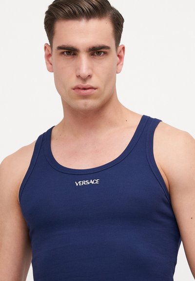 Marineblaues, geripptes Tanktop mit rundem Ausschnitt und weißem Versace-Logo auf der Brust. Glatte Baumwolltextur, körperbetonte Passform.