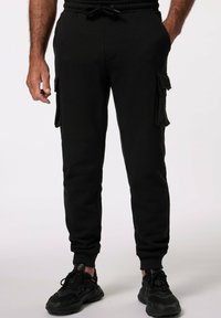 Schwarze Cargo-Sweatpants mit elastischem Bund, zwei Seitentaschen und zwei Cargotaschen an den Seiten. Weicher, strukturierter Stoff, schmal zulaufender Schnitt.