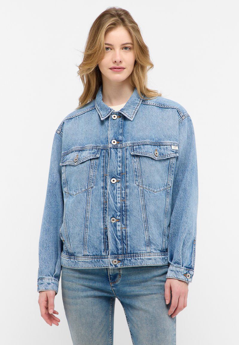 Veste en denim bleu clair avec fermeture à boutons, deux poches poitrine et coupe décontractée. Texture usée avec un design de col classique.
