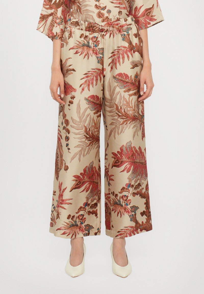 Beige vidde ben bukser med blomsterprint i røde og brune nuancer. Har elastik i taljen og en glat satinlignende tekstur.