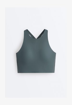 Ærmeløs, mørkegrøn sports-bh med høj halsudskæring og krydsede stropper bagpå på en hvid baggrund.