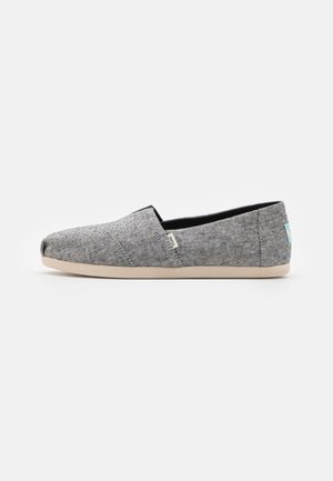 Grå slip-on hverdagssko med spættet stofoverdel og beige sål, med et lille side-tag i stof og en lyseblå hæl-label.