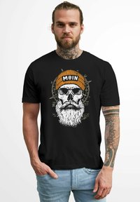 Schwarzes T-Shirt mit einem Grafikaufdruck eines Schädels mit einem weißen Bart, der mit einer orangefarbenen Strickmütze mit dem Aufdruck "MOIN" geschmückt ist. Lässiger Schnitt, Stoffstruktur nicht sichtbar.