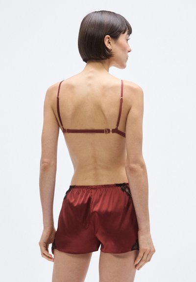 Set de lenjerie din satin burgund, cu dantelă delicată pe pantaloni scurți, bretele reglabile și finisaj neted. Conceput pentru confort și potrivire perfectă.
