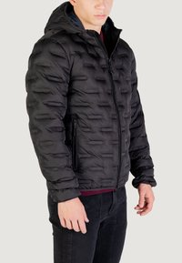 Giacca a vento nera con cappuccio, caratterizzata da un design trapuntato, chiusura con zip e due tasche laterali. Realizzata in materiale liscio e lucido.